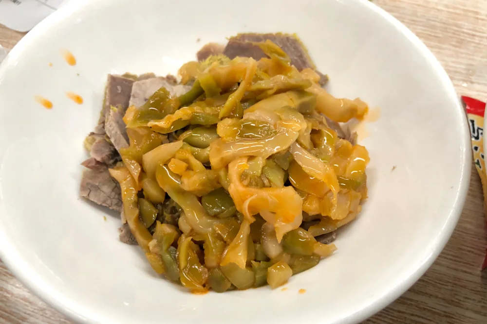餐桌小碗裡的榨菜與牛肉片